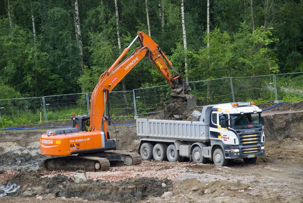 a crane has its arm lifted to remove the dump