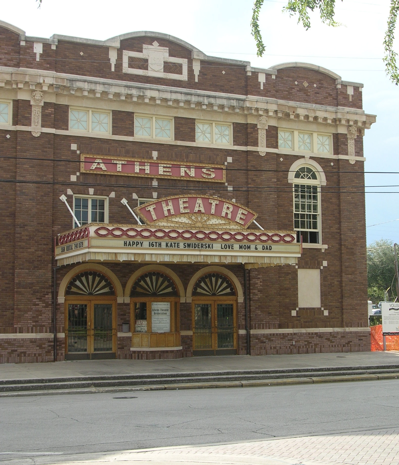 a large brick theater building on the side of the road