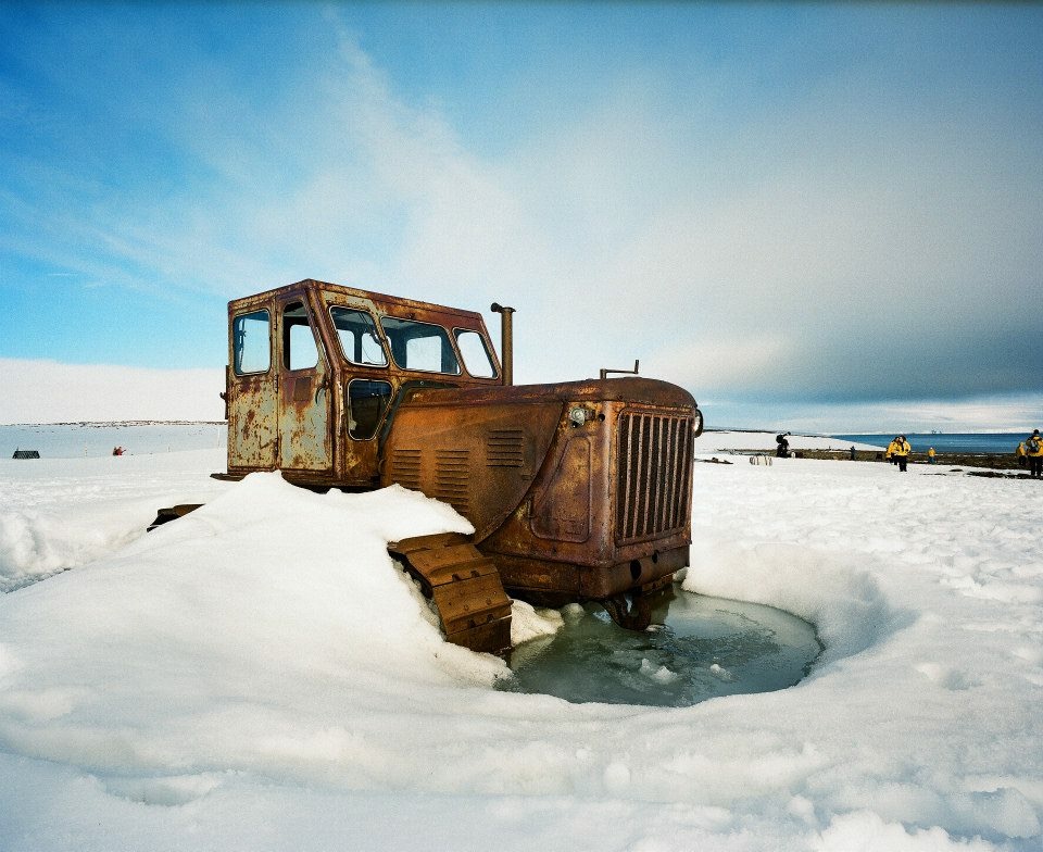 an old truck is surrounded by snow and ice