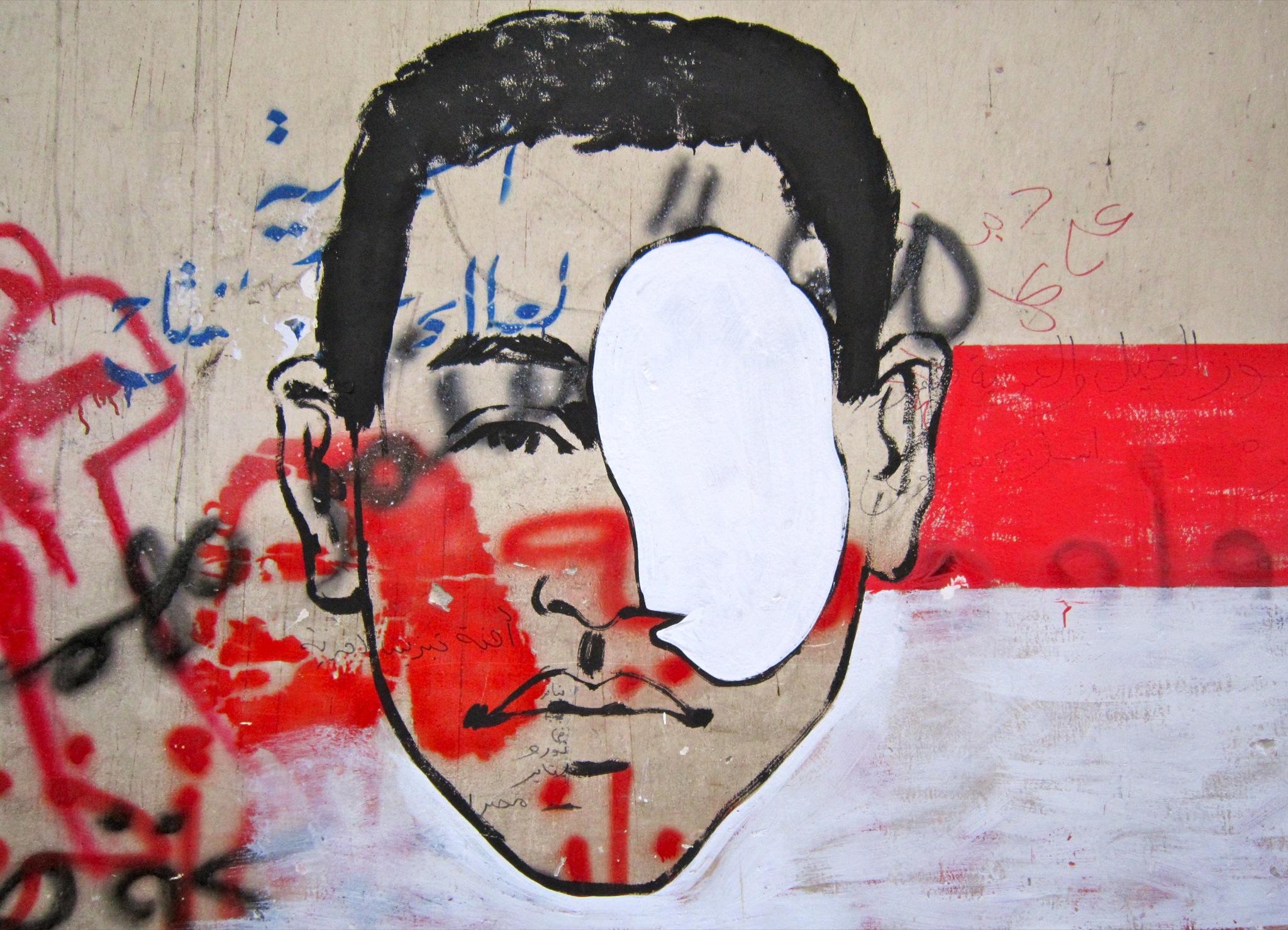 an advertit showing the face of a man on a wall covered in graffiti