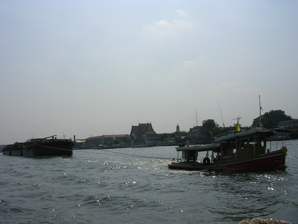 a boat sailing on water with houses in the background