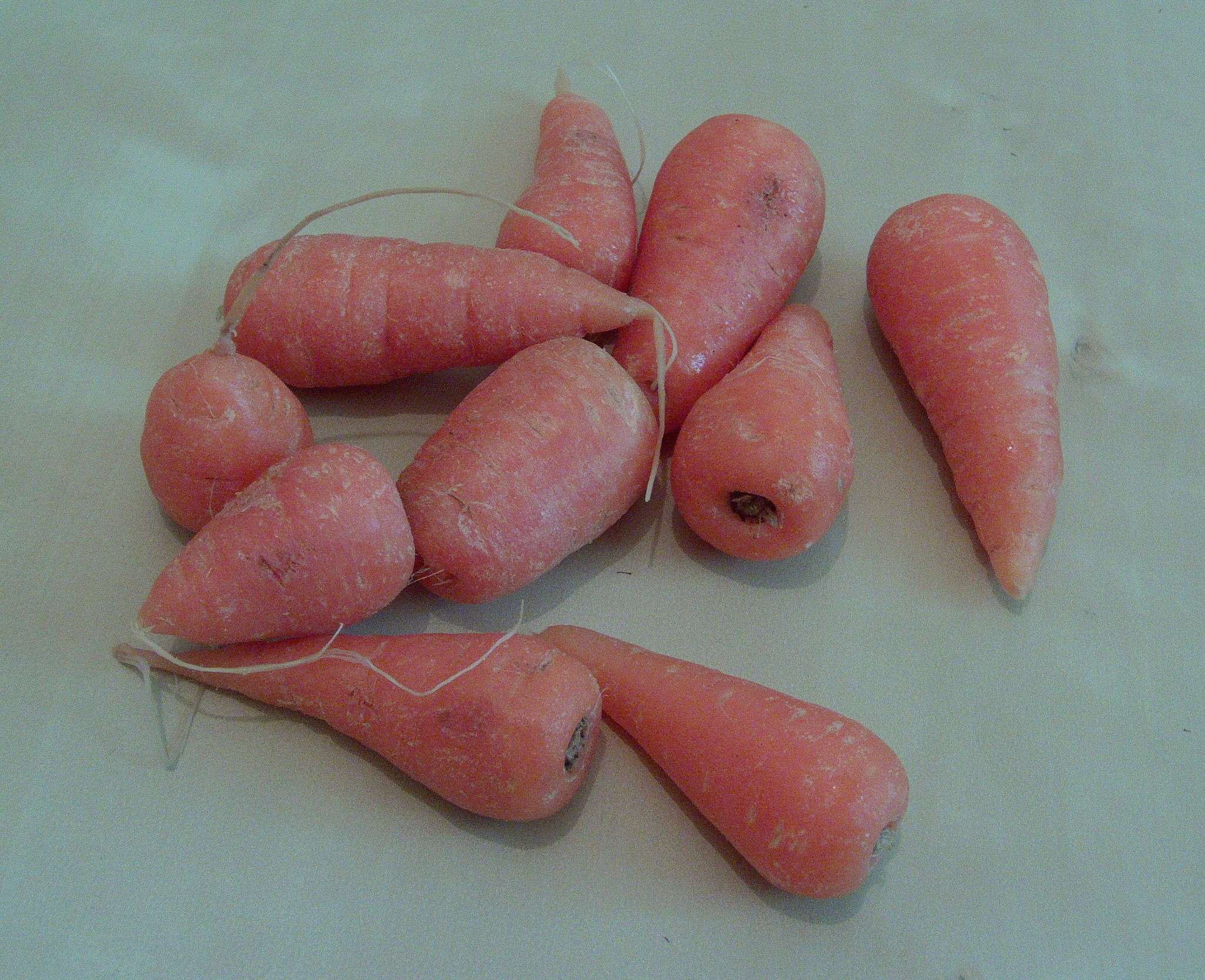 several orange carrots on a white surface