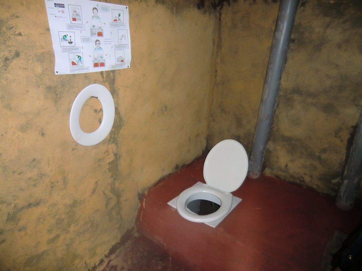 a bathroom with a toilet and a sign showing different toilet types