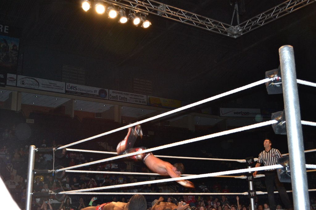 a woman in mid air after her match with a man in an arena
