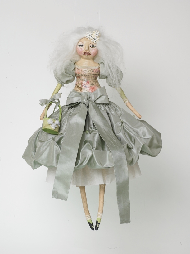a doll in an evening dress hanging on a hook