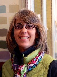 a woman with glasses and a green vest