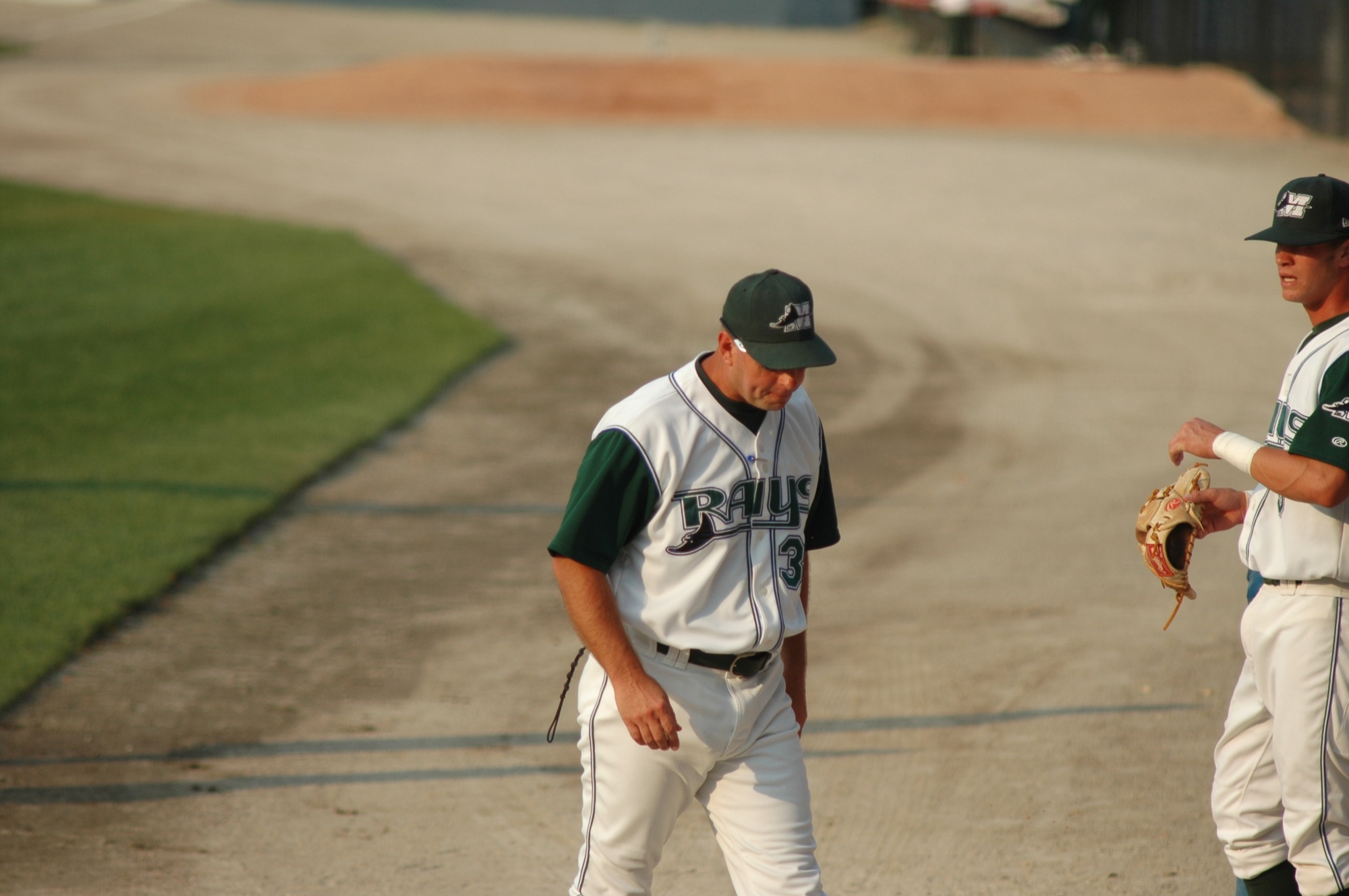 two baseball players are talking in a field