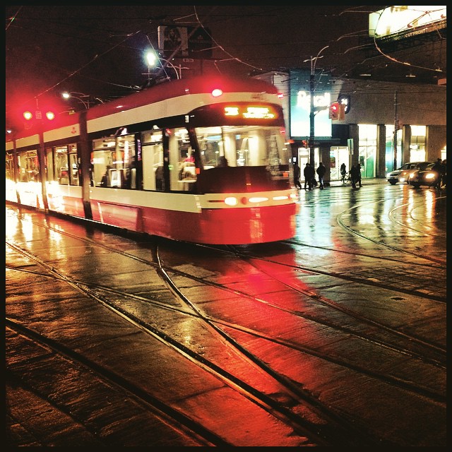 a city trolley at night with red lights shining