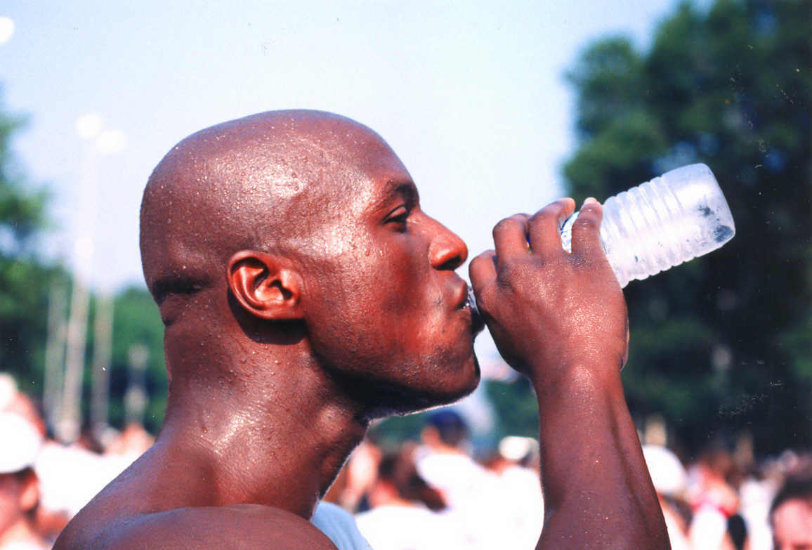 a black man drinking from a water bottle