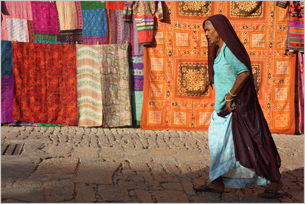a woman is walking past many colorful banners