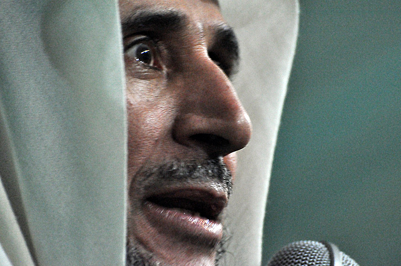 a man in white headdress with microphone