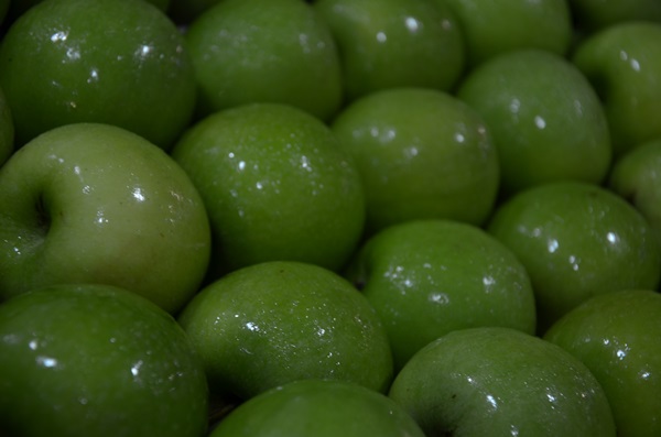 the green apples are in large piles