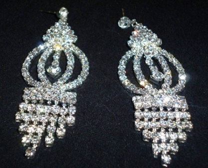 some diamond earrings that are sitting on a black cloth