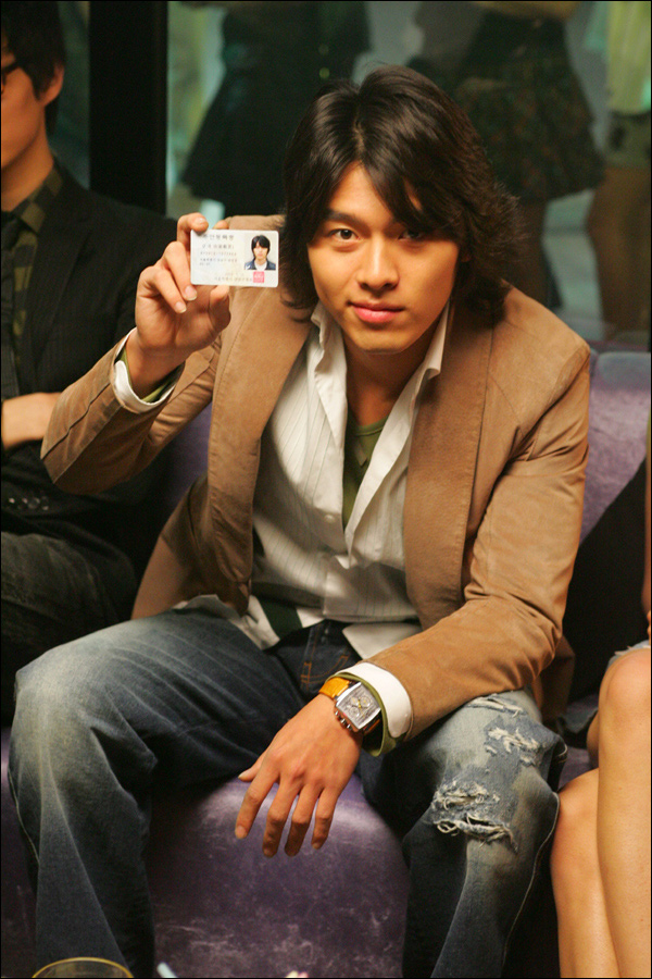 a man holding a business card in one hand and a smart phone in the other