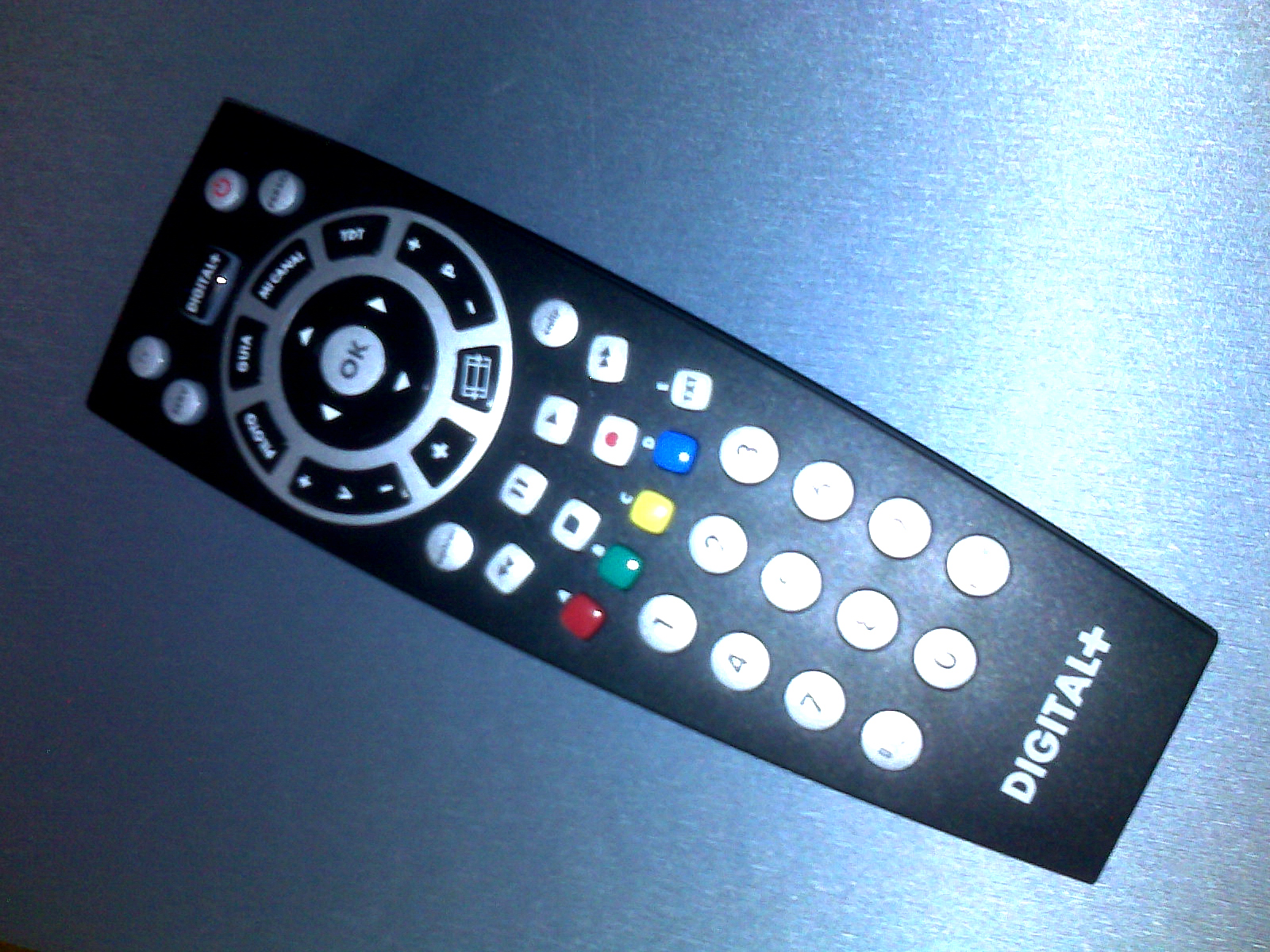 a black remote control on a silver surface