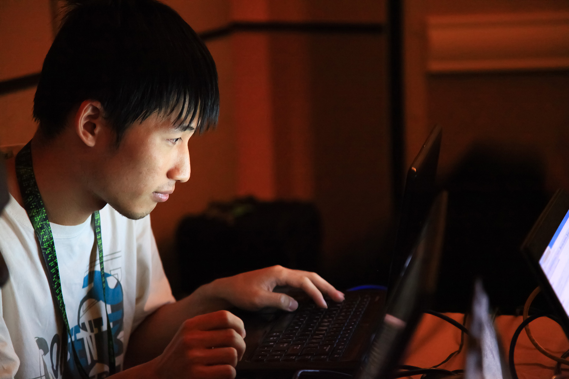 a man using a laptop at night in a dimly lit room