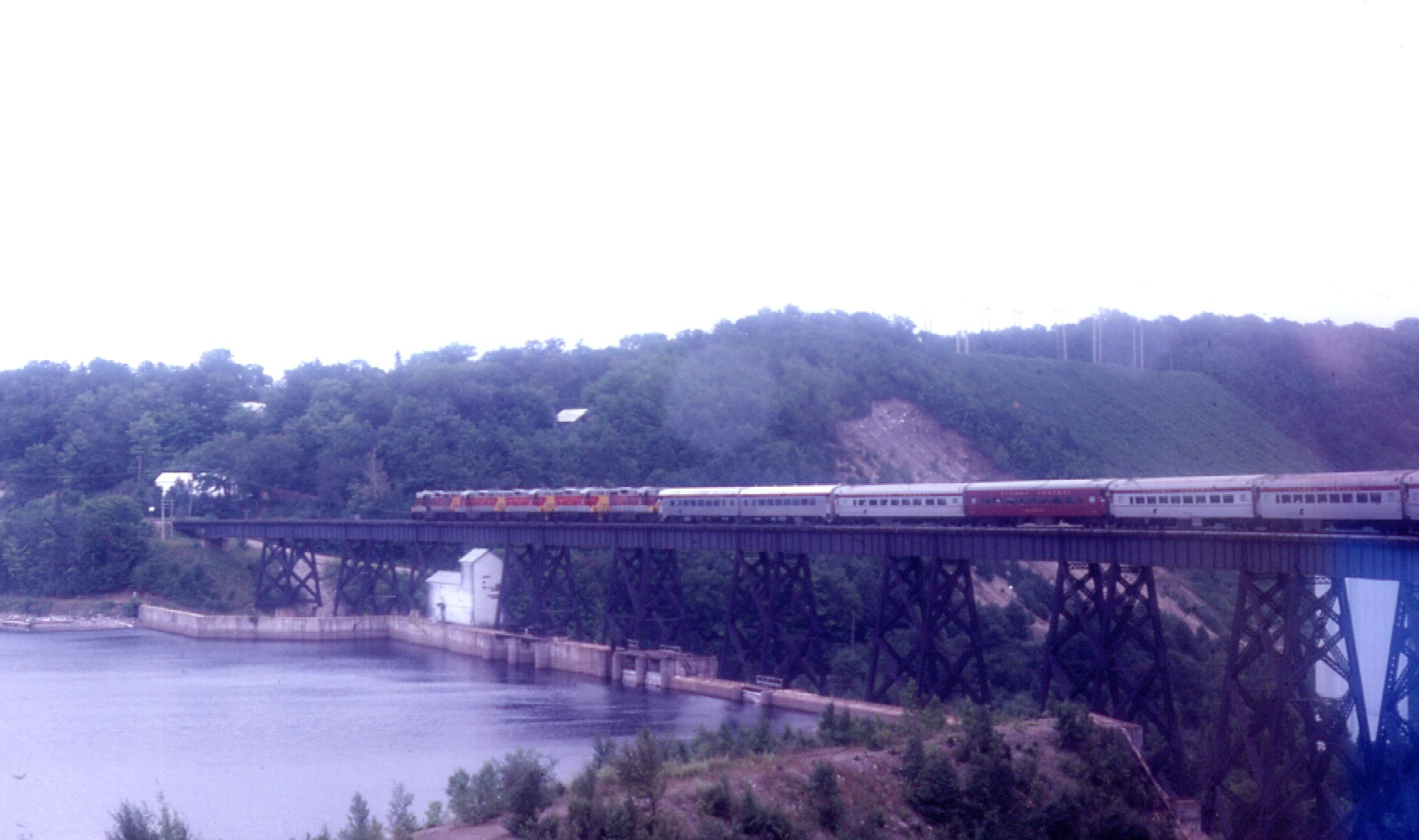 a train moving across the bridge near water