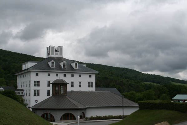 a large white building in front of mountains