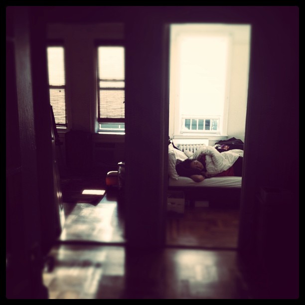 a woman laying in bed near two open doors