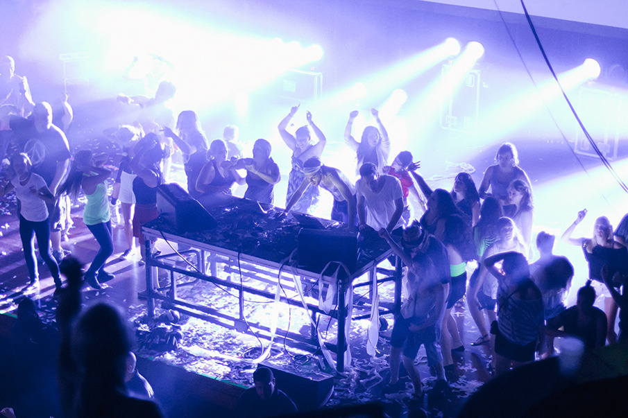 a crowd of people are standing on stage in front of a speaker