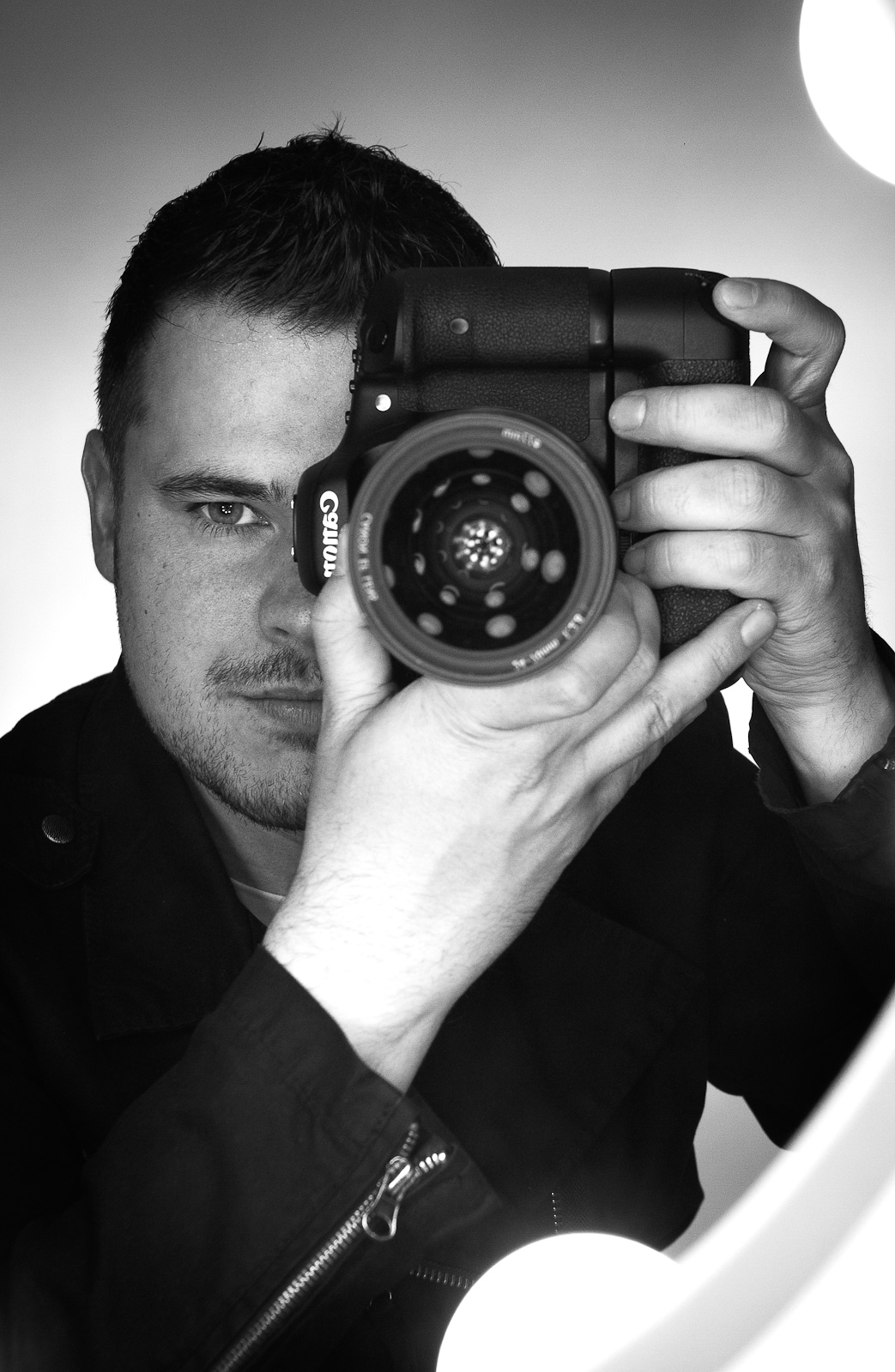 a man holding up an old fashioned camera to his face