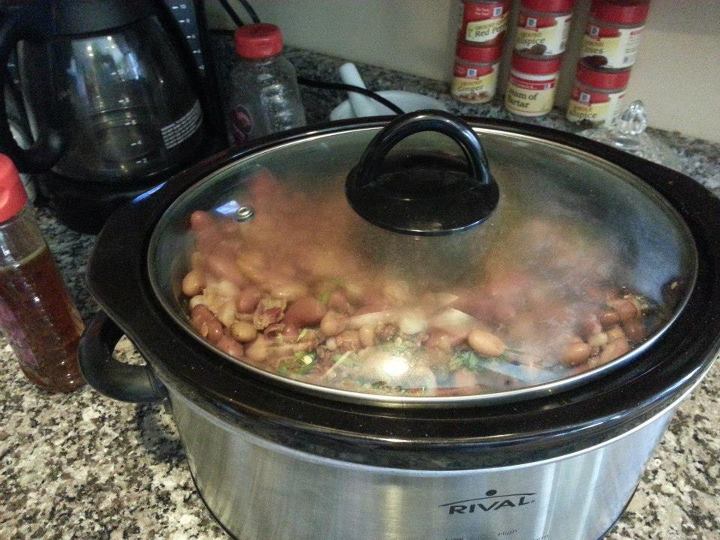 a bowl filled with stew near bottles and sauce