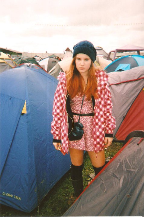 a woman standing near a tent full of tents