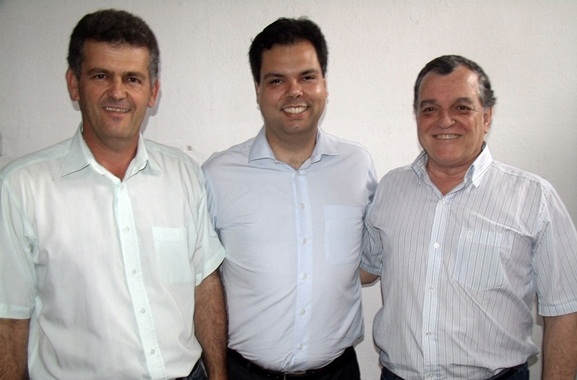 three men smile brightly while standing next to each other