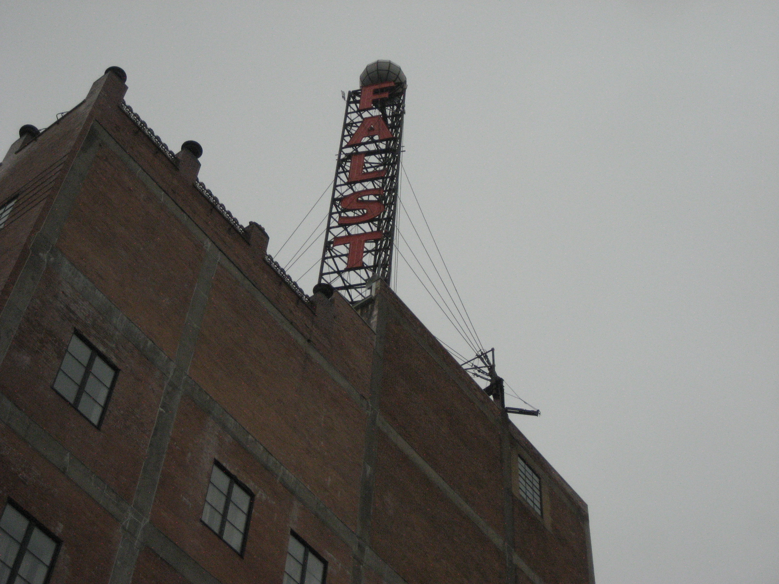 a tall brick building with a sign on the top