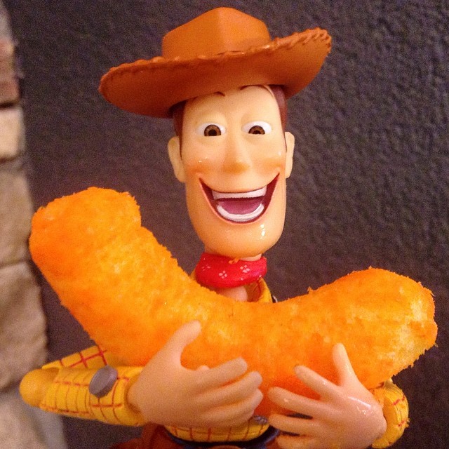 a toy person with a cowboy hat holding up some doughnut