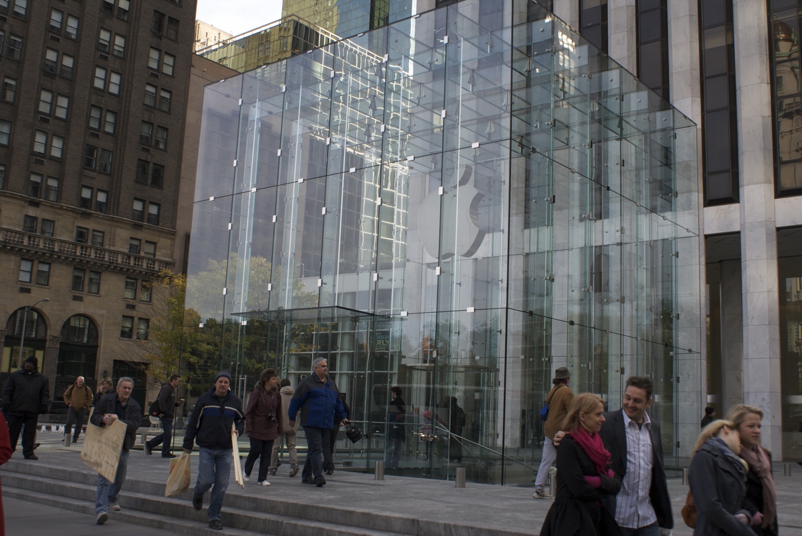 people walking on the stairs in front of a building