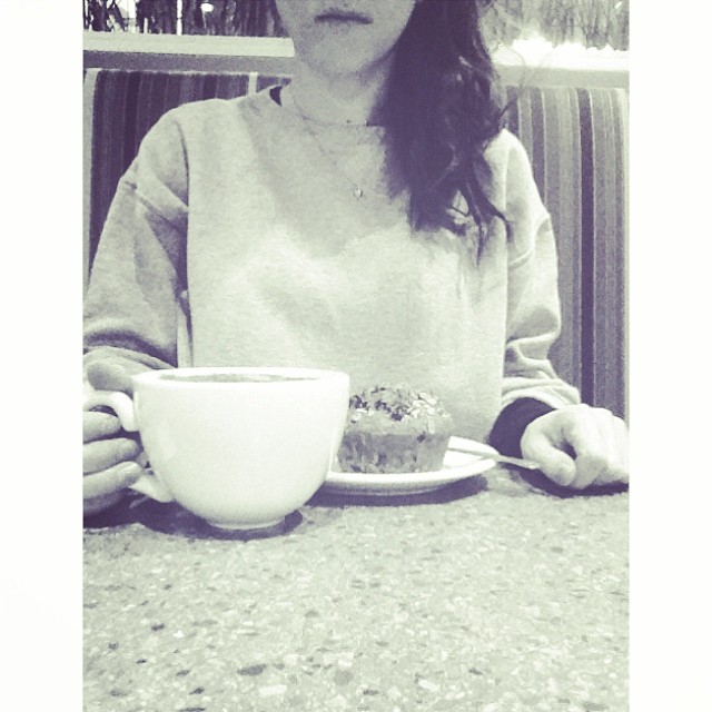 a woman sitting in front of a cup with a cake in it