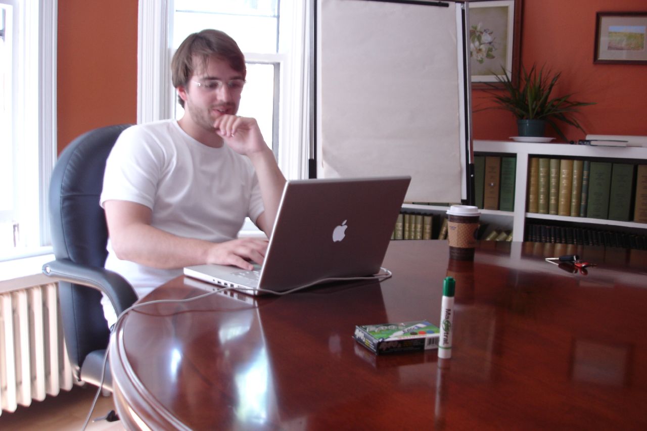 a man sitting at a table with his lap top