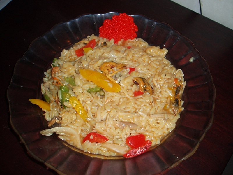 a close up of rice with vegetables and meat in a bowl