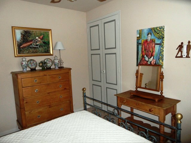 a bedroom that has a dresser and a bed in it
