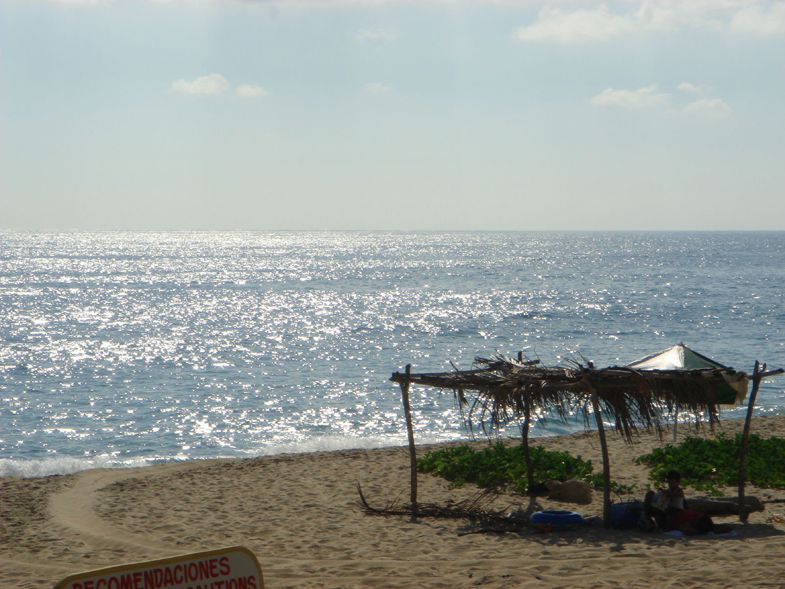 a beach with some umbrellas and people laying under it