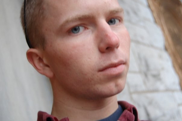a young man with blue eyes is looking into the camera