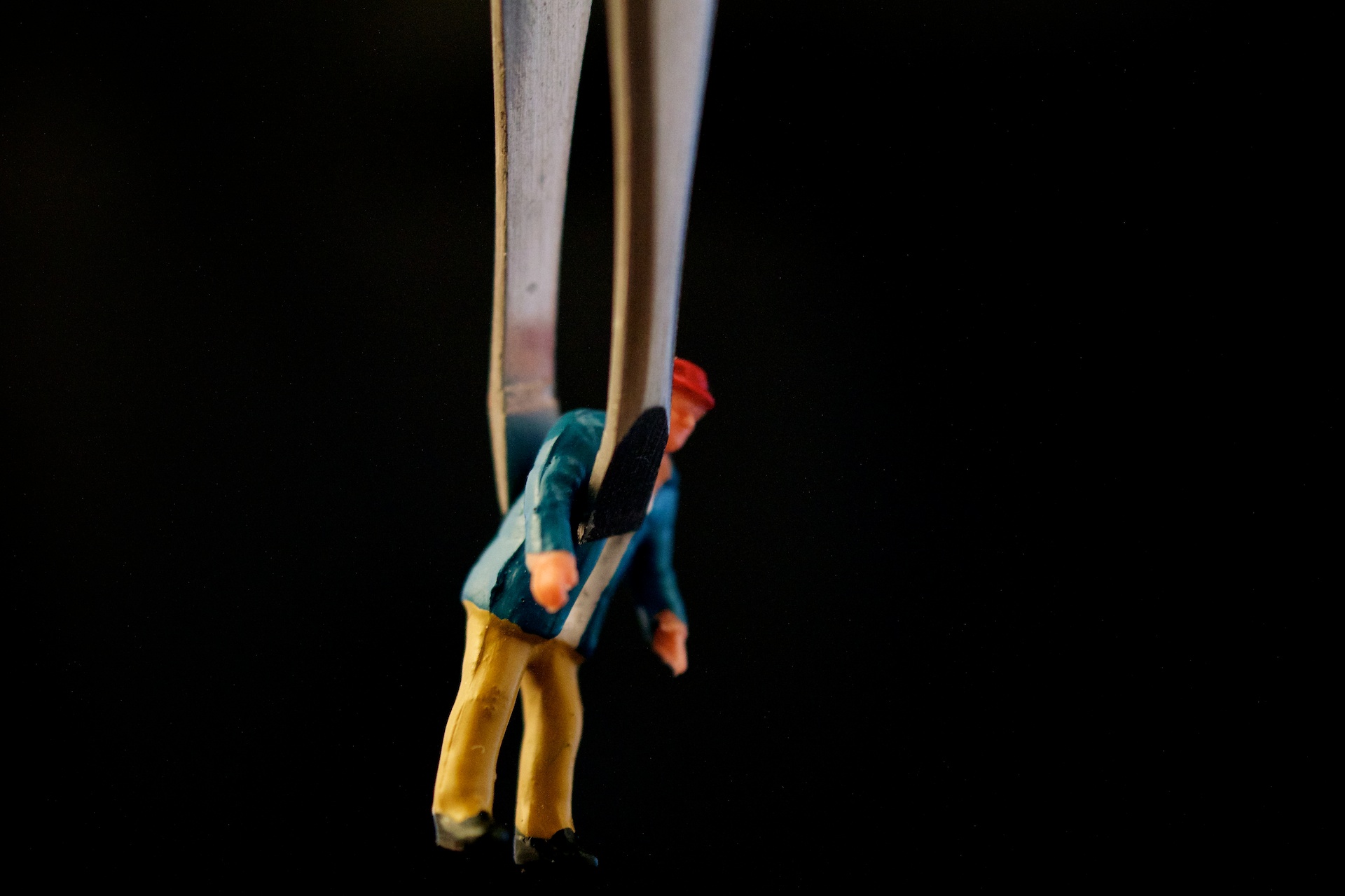 two different colored toy figures holding together on the end of some strings