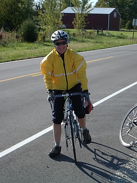 a man in yellow jacket and black shorts riding a bike