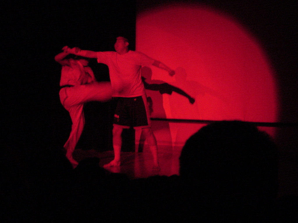 a man and woman perform in a dark circus