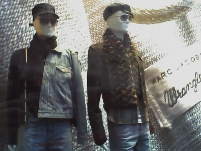 two mannequins in jackets and hats stand on display