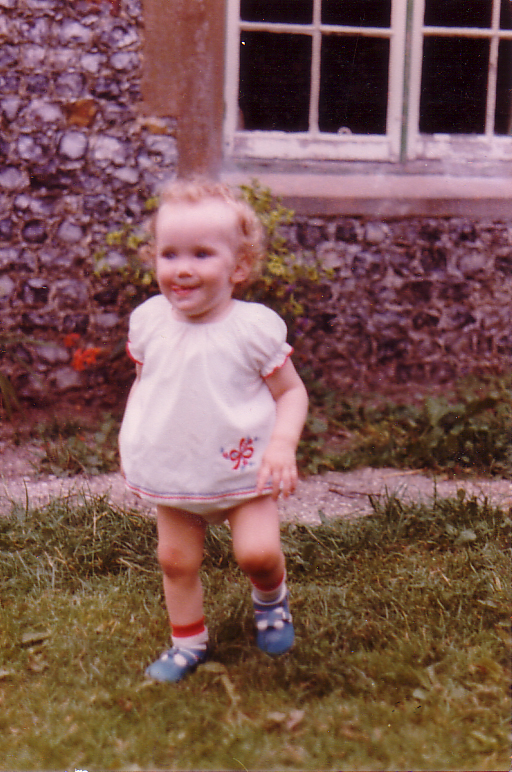 a young child standing in the grass wearing socks