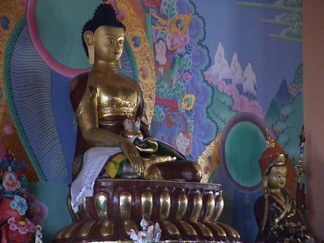 a golden buddha statue sits in the middle of a room