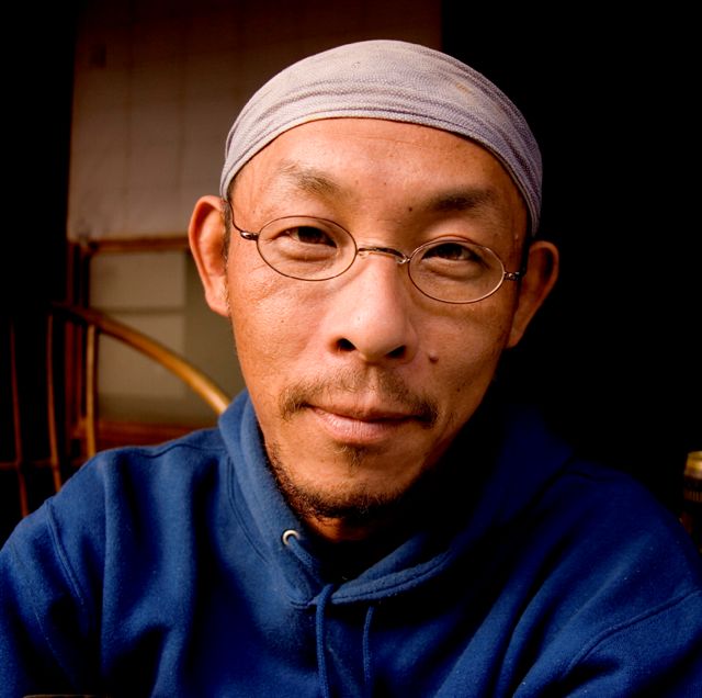 a close up s of a man in glasses and a headscarf
