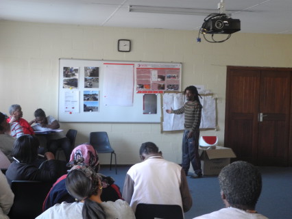 students in class and one person standing with a video camera