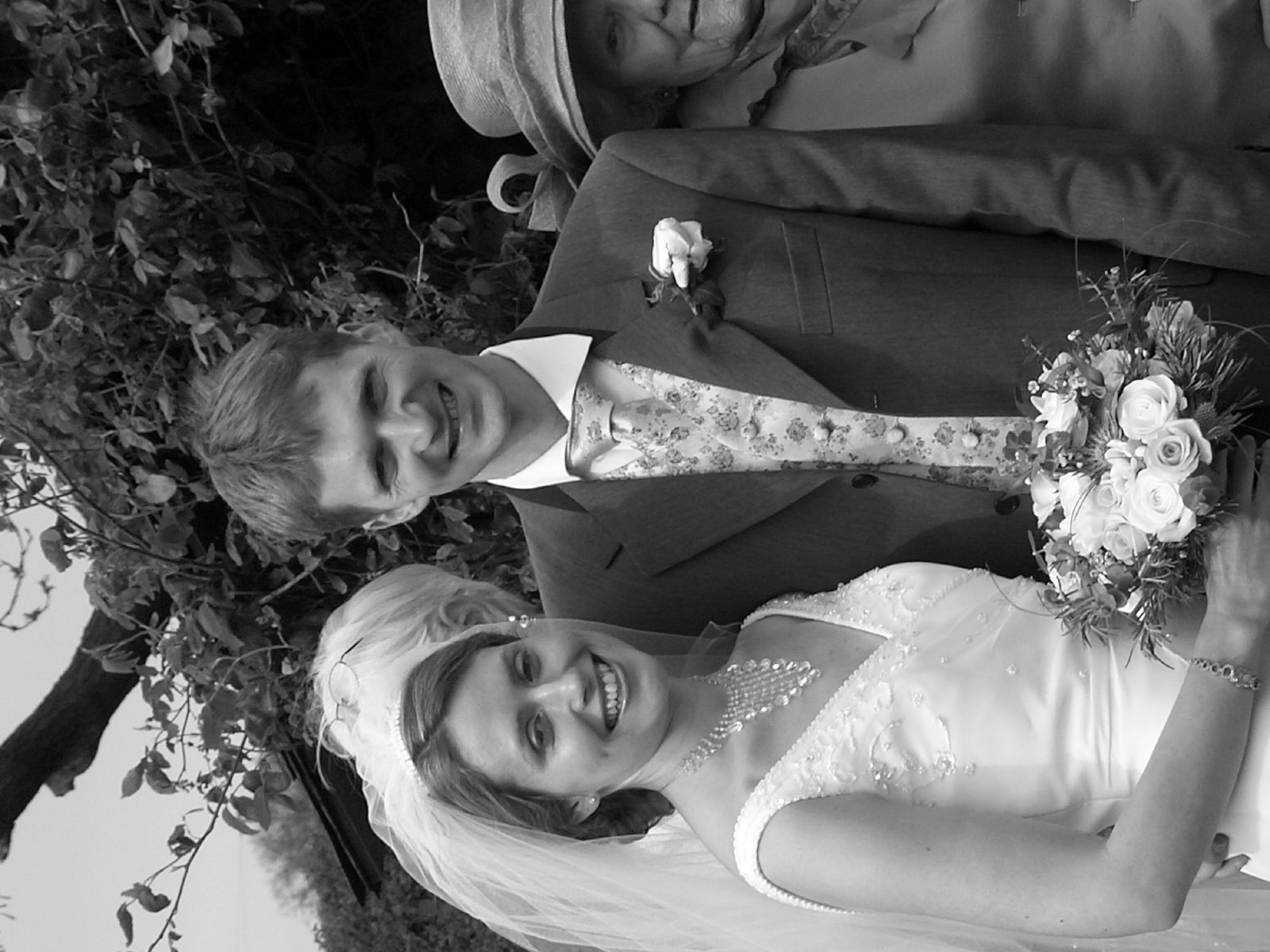 black and white image of bride and groom with older women