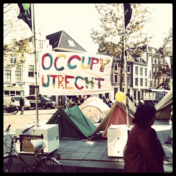 people standing next to tents with occupy up on it