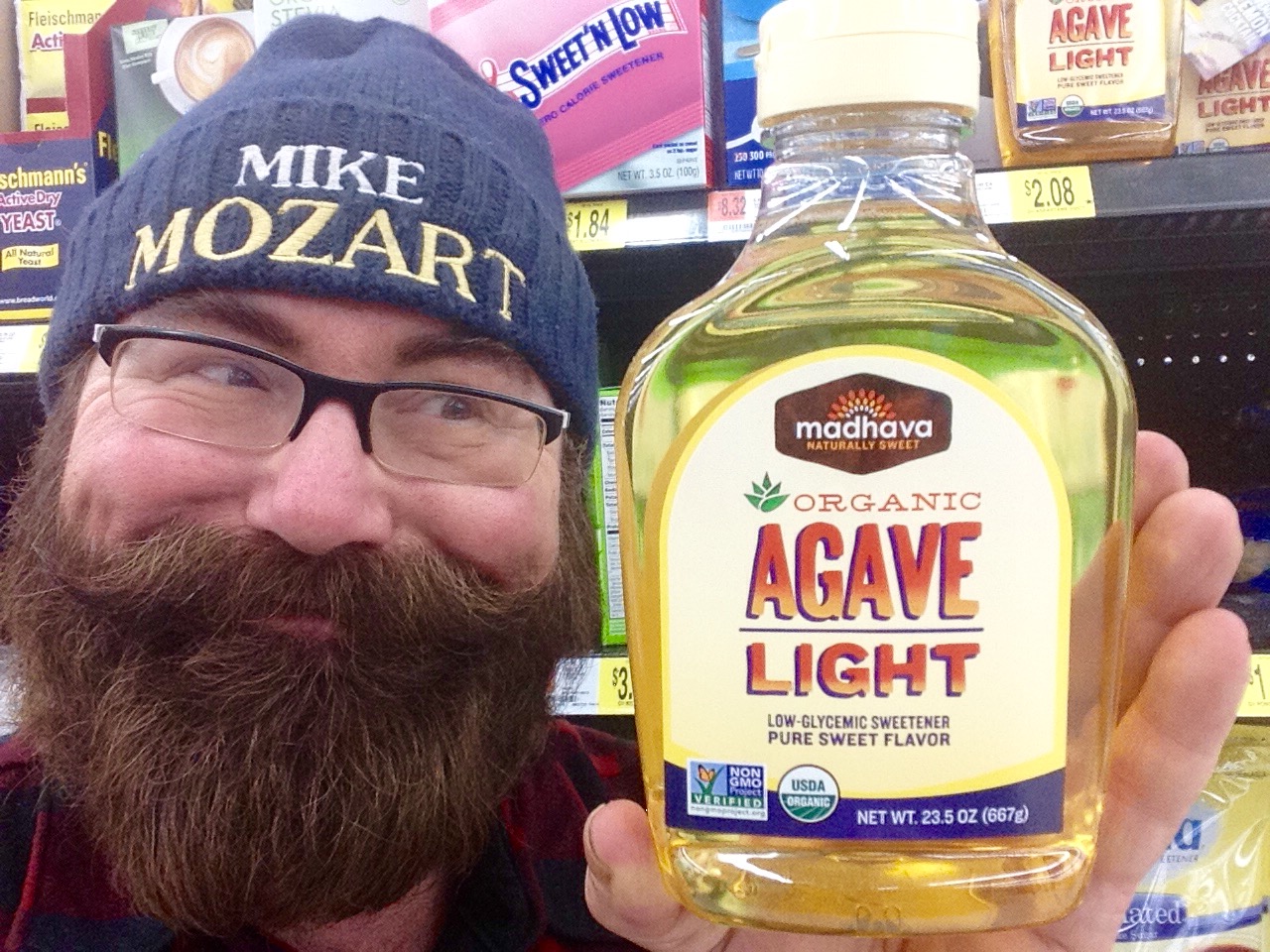 a man holding up a bottle of organic agave light