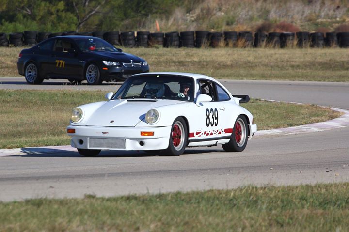 a white sports car driving down a track