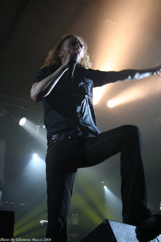 man standing on stage, his legs stretched out
